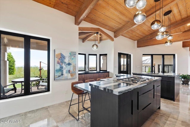 kitchen featuring wooden ceiling, a center island, decorative light fixtures, stainless steel gas cooktop, and sink