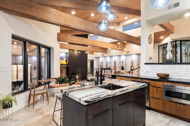 kitchen featuring a kitchen island, tasteful backsplash, hanging light fixtures, wooden ceiling, and beam ceiling