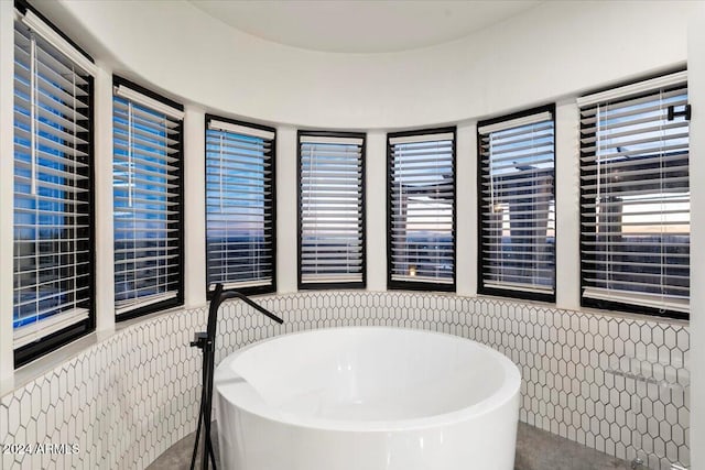 bathroom featuring tile walls and a bathtub