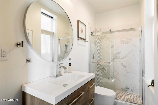 bathroom with toilet, a shower with door, and vanity