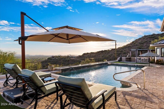 view of swimming pool featuring a hot tub, pool water feature, and a patio