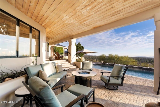 view of patio / terrace with an outdoor living space with a fire pit and a fenced in pool