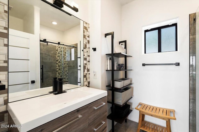 bathroom with a tile shower and vanity