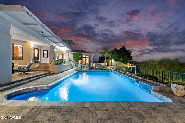 pool at dusk with a patio