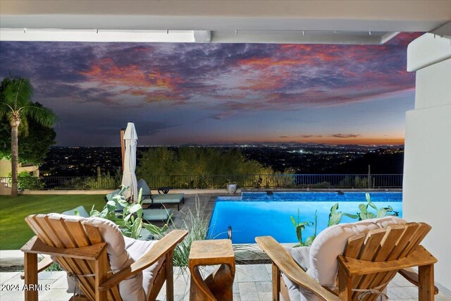 pool at dusk featuring pool water feature