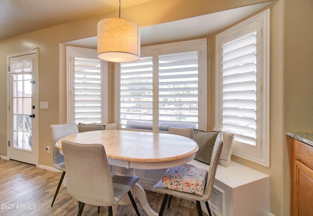 dining space with baseboards and light wood finished floors