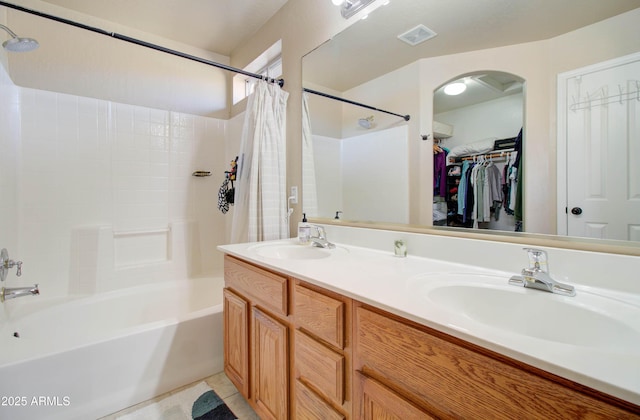 full bathroom with a sink, visible vents, double vanity, and a spacious closet