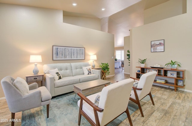 living area featuring recessed lighting, baseboards, high vaulted ceiling, and light wood finished floors