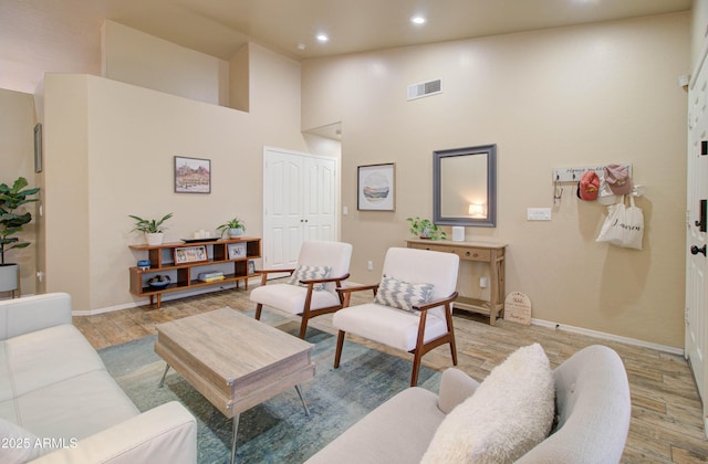 living area with recessed lighting, visible vents, light wood-style flooring, and baseboards