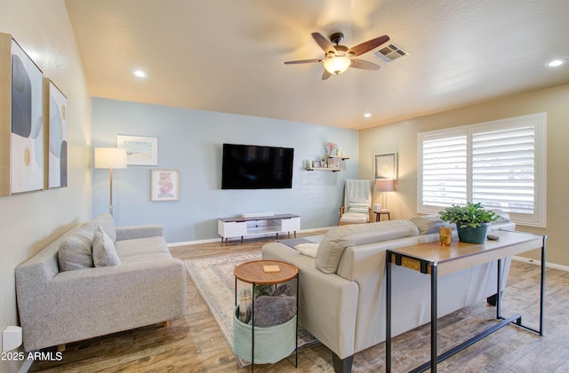 living area with recessed lighting, wood finished floors, and visible vents