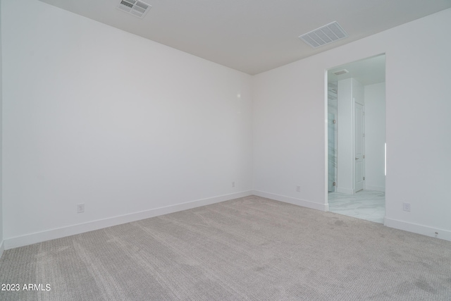 unfurnished room featuring light carpet