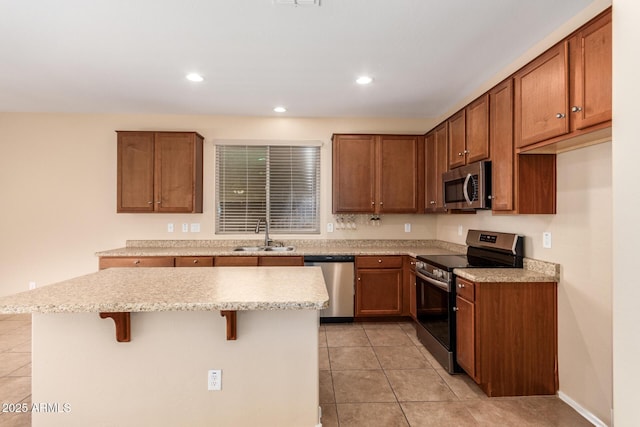 kitchen featuring a kitchen island, appliances with stainless steel finishes, a breakfast bar, and sink