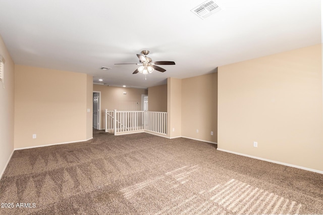 carpeted spare room featuring ceiling fan