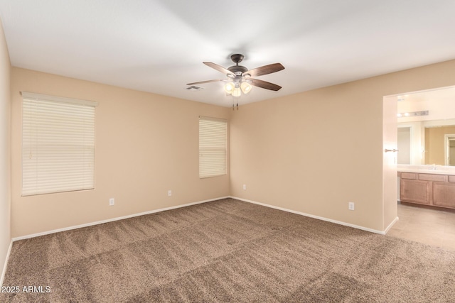 empty room featuring ceiling fan and light carpet