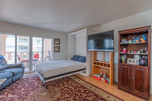 bedroom featuring access to outside and wood finished floors