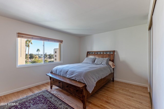 bedroom featuring light wood-style flooring and baseboards