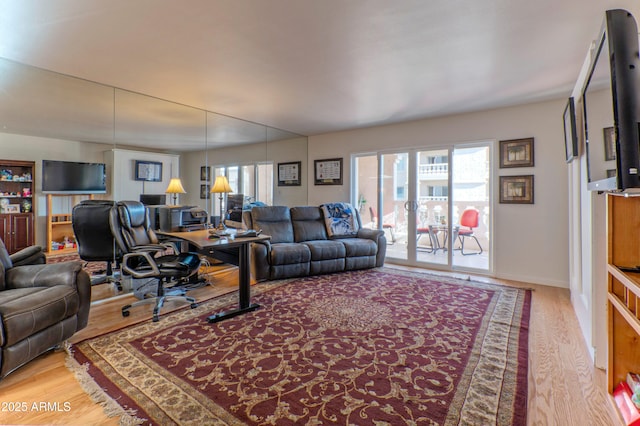 living area with light wood-type flooring and baseboards