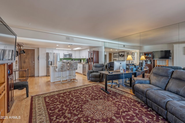 living room with light wood finished floors and visible vents