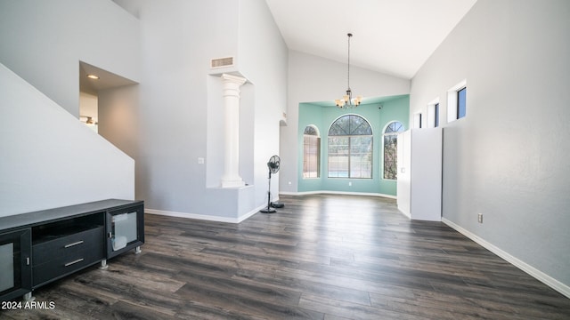 living room with high vaulted ceiling, a notable chandelier, dark hardwood / wood-style flooring, and decorative columns