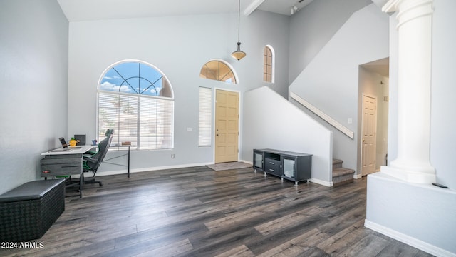 foyer entrance with high vaulted ceiling, dark hardwood / wood-style flooring, beamed ceiling, and ornate columns