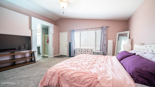 carpeted bedroom with ensuite bathroom and lofted ceiling