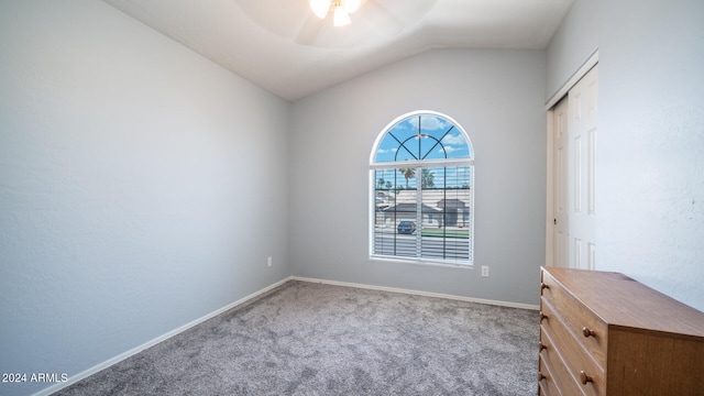 carpeted spare room with ceiling fan and lofted ceiling