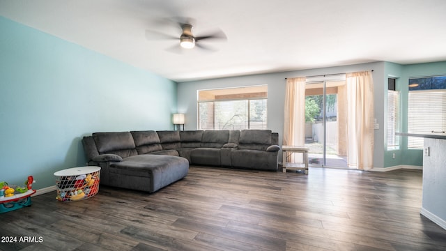 living room featuring dark wood-type flooring and ceiling fan