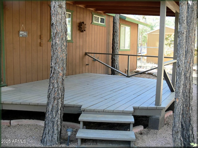 wooden terrace featuring a storage shed