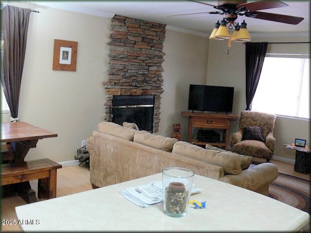 living room with a fireplace, light wood-type flooring, and crown molding