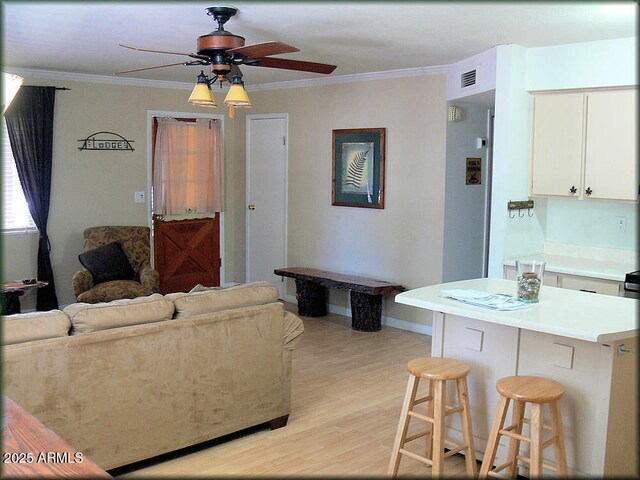 living room with crown molding, ceiling fan, and light hardwood / wood-style floors