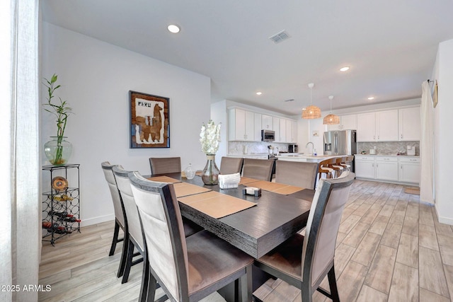 dining room with light wood-type flooring, visible vents, and recessed lighting