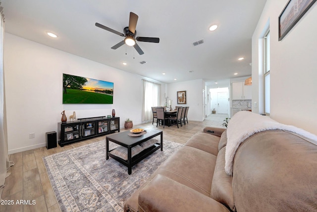 living area featuring a ceiling fan, visible vents, baseboards, recessed lighting, and light wood-style floors