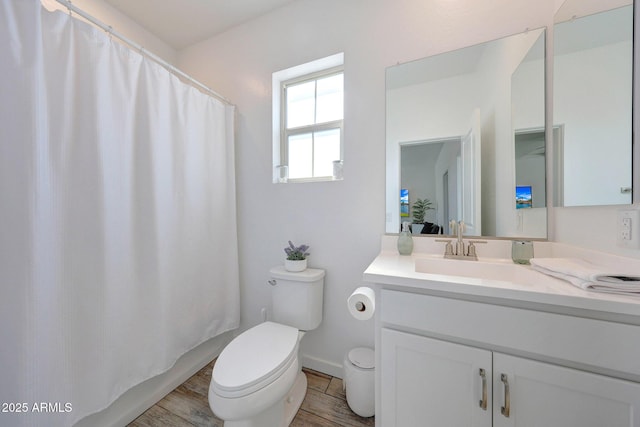 bathroom with vanity, a shower with curtain, toilet, and wood finished floors