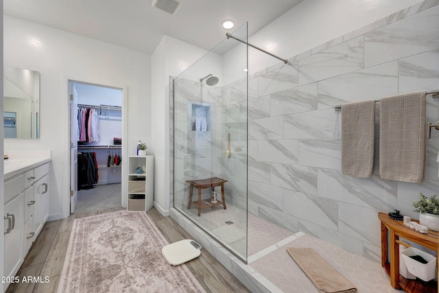 full bath with visible vents, a spacious closet, walk in shower, and vanity