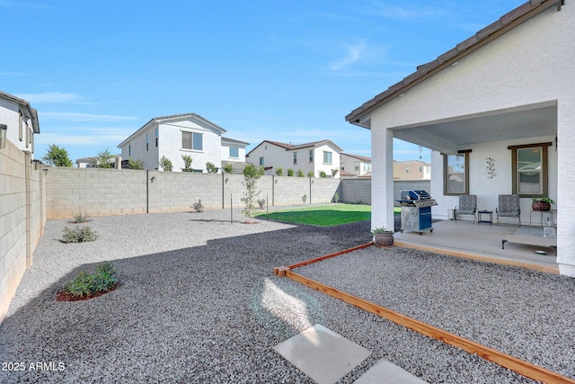 view of yard with a residential view, a patio, and a fenced backyard