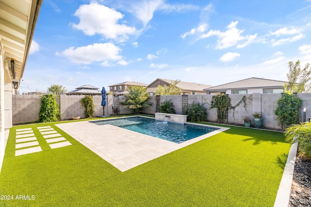 view of pool with a lawn, a patio area, and pool water feature