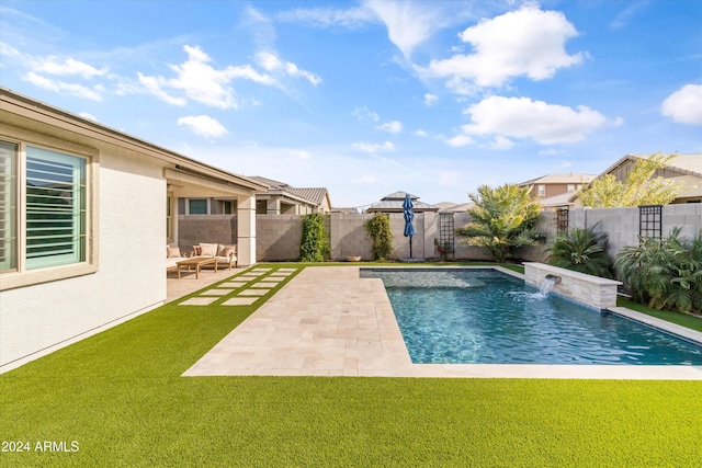 view of pool with pool water feature, a patio, and a lawn