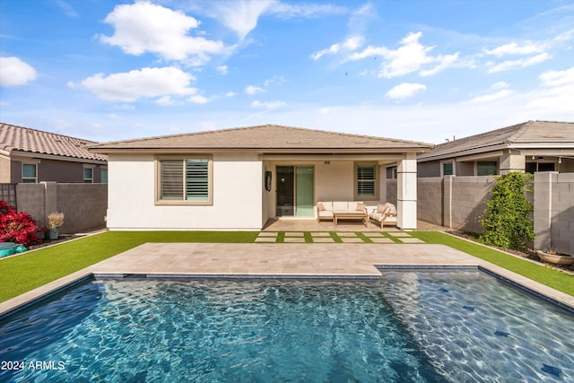 back of property featuring an outdoor hangout area, a fenced in pool, and a patio area