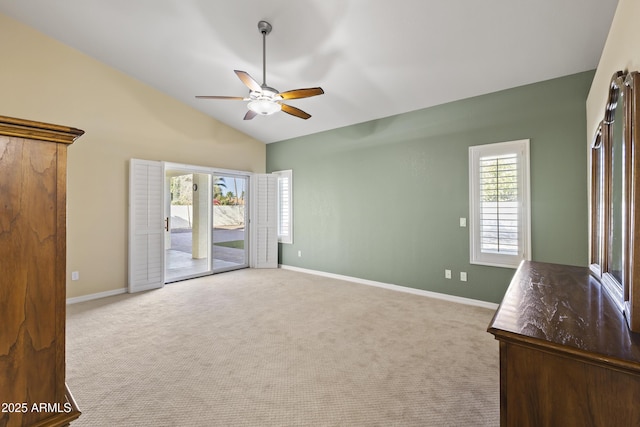 interior space featuring light carpet, ceiling fan, lofted ceiling, and baseboards