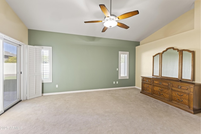 unfurnished bedroom featuring light carpet, baseboards, lofted ceiling, and access to exterior