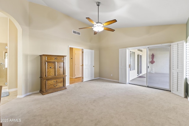 unfurnished bedroom with arched walkways, visible vents, light carpet, access to outside, and baseboards