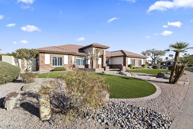 mediterranean / spanish house with brick siding, fence, and a tiled roof