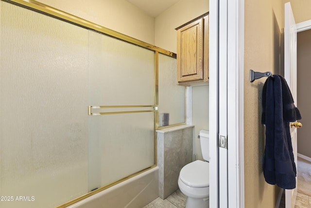 bathroom with shower / bath combination with glass door and toilet