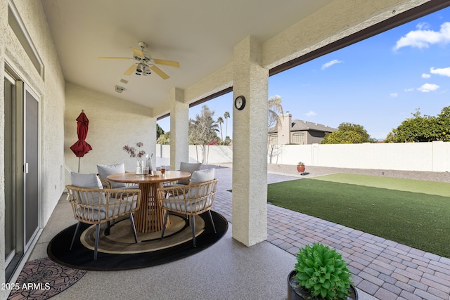 view of patio / terrace featuring outdoor dining area, a fenced backyard, and a ceiling fan