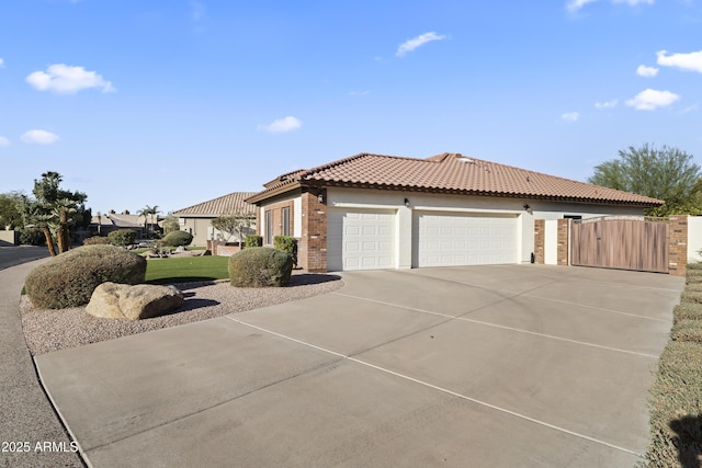 view of front of house featuring a garage, a tiled roof, concrete driveway, and stucco siding