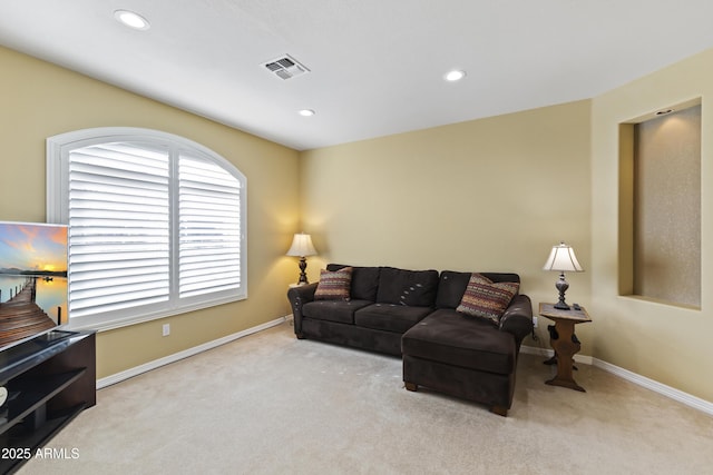 living area featuring baseboards, recessed lighting, visible vents, and light colored carpet