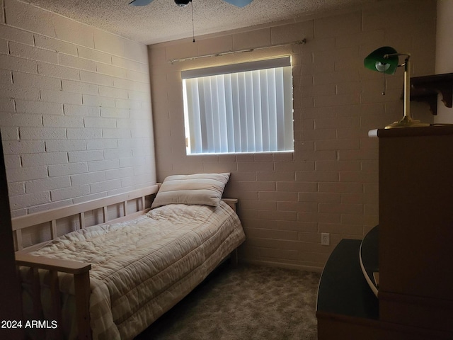 carpeted bedroom featuring a textured ceiling, brick wall, and ceiling fan