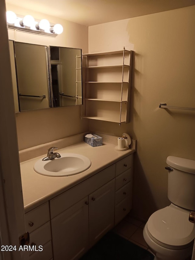 bathroom with toilet, tile patterned flooring, and vanity