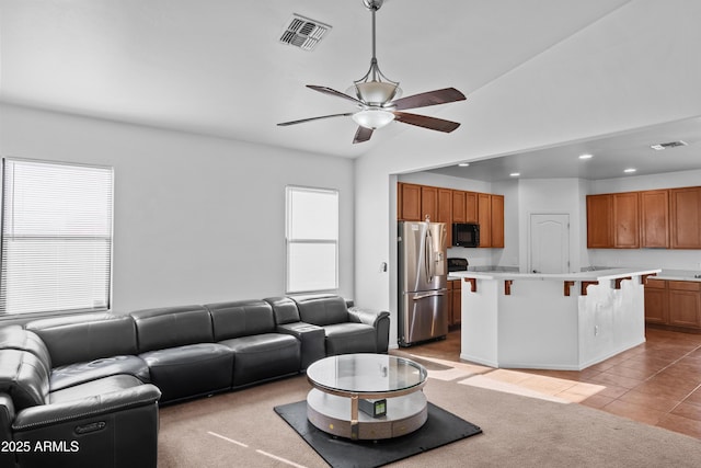 living room with ceiling fan, a wealth of natural light, lofted ceiling, and light colored carpet