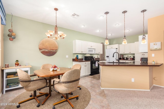 kitchen featuring pendant lighting, white appliances, white cabinetry, kitchen peninsula, and a notable chandelier